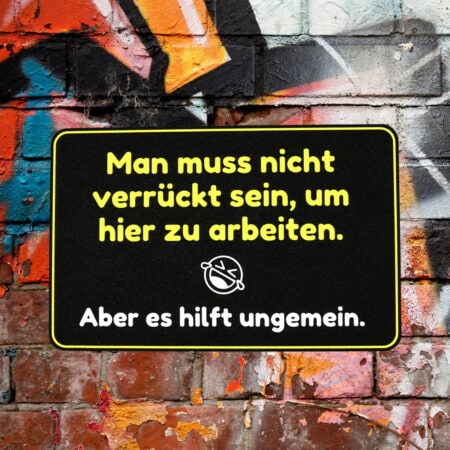 Schild: Man muss nicht verrückt sein um hier zu arbeiten, aber es hilft ungemein.